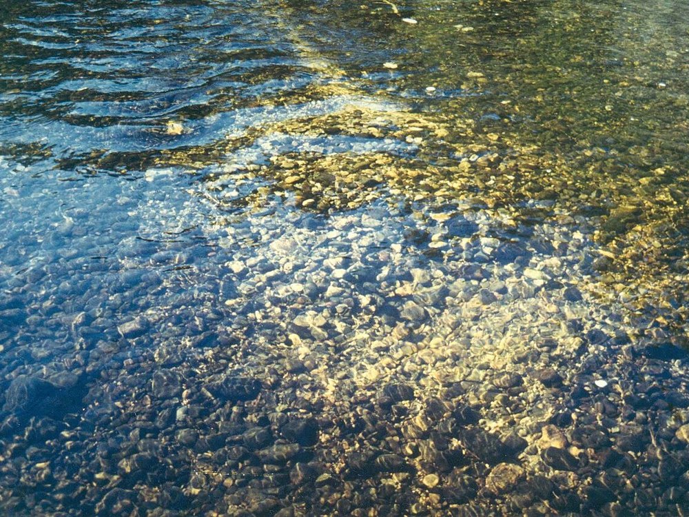 A clear, shallow river running over cobbles and gravel